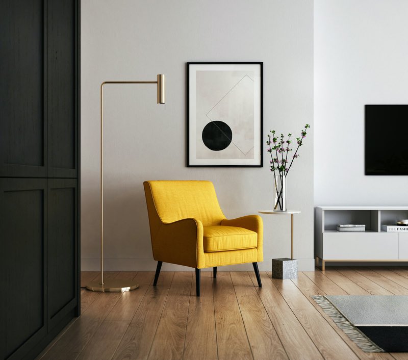 Living room corner with a yellow armchair on a warm wooden floor